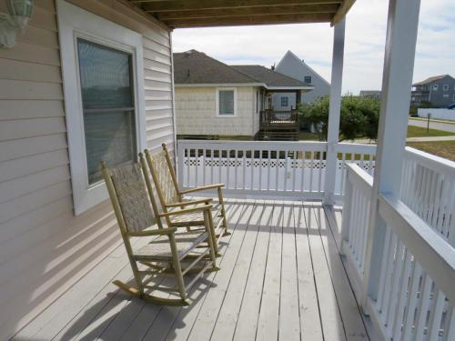 two rocking chairs on the porch of a house at It's A Vibe in Kitty Hawk