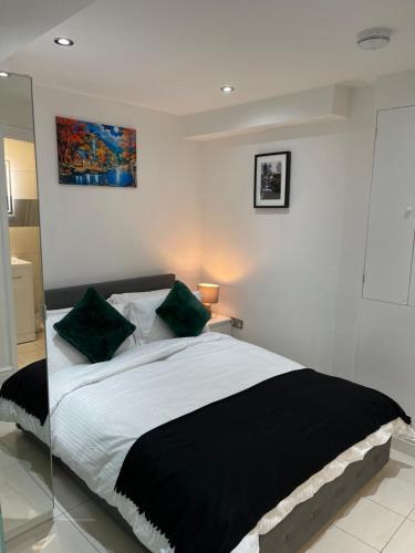 1 dormitorio con 1 cama grande con almohadas verdes en Modern 1 Bedroom Holiday Apartment in Southminster en Southminster