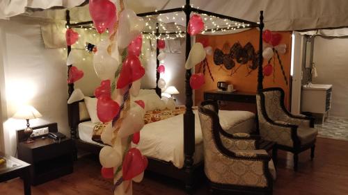 a bedroom with a bed with red and white balloons at The Bugyal in Kanatal
