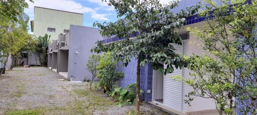 a building with blue shutters on the side of it at Pousada Village Maitinga in Bertioga