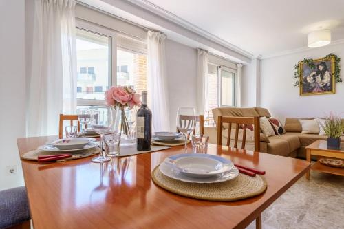 a dining room with a wooden table with a bottle of wine at MalagaSuite Torremolinos Lovely & Comfy in Torremolinos