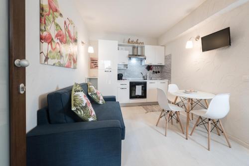 un soggiorno con divano blu e tavolo di Resilienza Tropical Apartments & Room a Porto SantʼElpidio