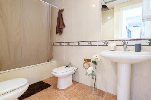a bathroom with a sink and a toilet and a mirror at MalagaSuite Torremolinos Lovely & Comfy in Torremolinos