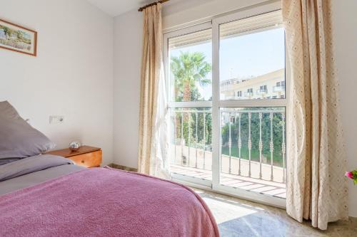 a bedroom with a bed and a large window at MalagaSuite Torremolinos Lovely & Comfy in Torremolinos