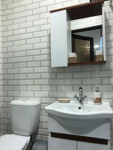 a white bathroom with a toilet and a sink at LukasSaloMea in Borjomi