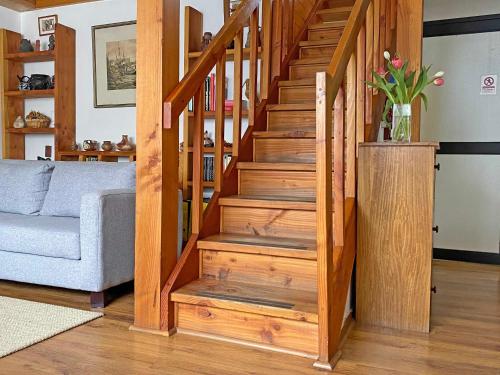 escalera de madera en la sala de estar con sofá en Novaqua Bed & Breakfast en Olmué