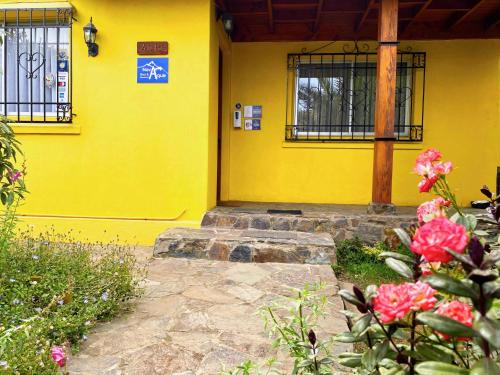 un edificio amarillo con una ventana y algunas flores rosas en Novaqua Bed & Breakfast, en Olmué