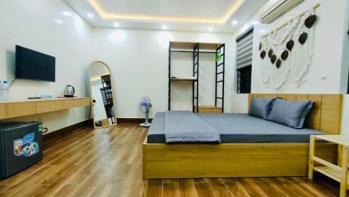 a bedroom with a bed and a television in it at Hương Cảng Homestay in Hai Phong