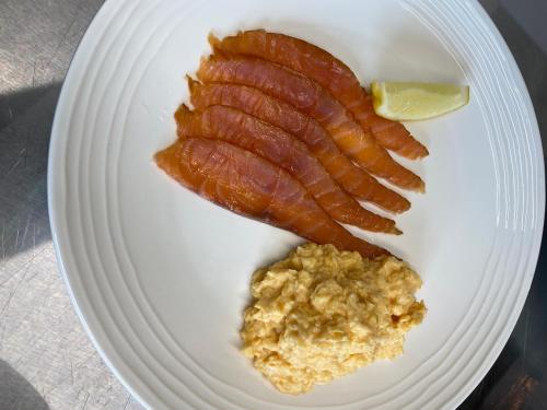 Taransay House, Small Hotel في بورتري: طبق عليه قطعة من لحم الخنزير المقدد وشريحة من الليمون