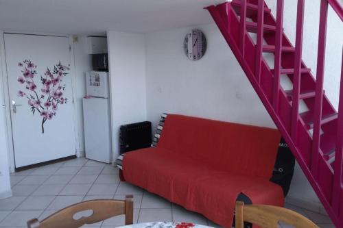 ein Wohnzimmer mit einem roten Sofa und einer Treppe in der Unterkunft Bright duplex with magnificent sea view in Saint-Mandrier-sur-Mer