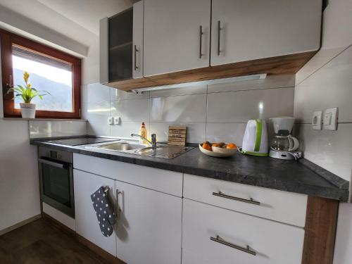 a kitchen with white cabinets and a sink at Apartments Irena in Bohinj