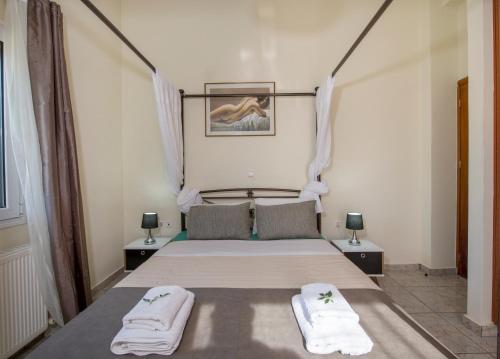 カラタスにあるIfigeneia's Lavish Escape with Private Hot Tubのベッドルーム1室(ベッド1台、タオル2枚付)
