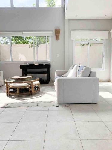 a living room with a white couch and a piano at Casa para familia em Riviera, com WiFi in Bertioga