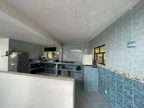 a kitchen with blue tiles on the walls and a refrigerator at Encantadora Finca privada con piscina, El Mirador in Fusagasuga