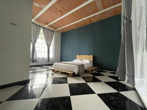 a bedroom with a bed and a black and white checkered floor at Encantadora Finca privada con piscina, El Mirador in Fusagasuga