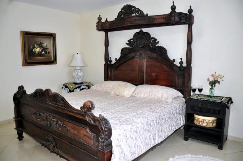 1 dormitorio con 1 cama grande de madera en una habitación en ANGEL'S SEA Pousada en Rio das Ostras