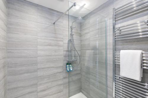a bathroom with a shower with a glass door at Lovely, modern & spacious 1-bed flat central Hove in Brighton & Hove