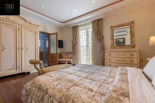 a bedroom with a large bed and a dresser at LUX VILLA with amazing BBQ, Pool Area & WIFI by 360 Estates in Is-Swieqi