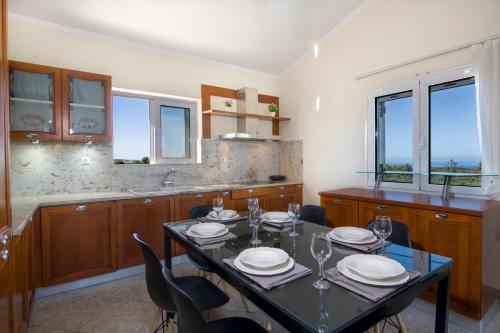 comedor con mesa y sillas en la cocina en Ifigeneia's Luxury Resort with Private Hot Tub, en Kalathas