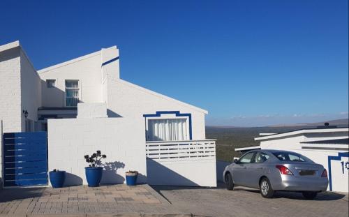 a car parked in front of a white house at SONVANGER VILLA YZERFONTEIN in Yzerfontein