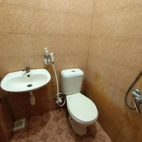 uma casa de banho com um WC e um lavatório em Fans Bright Batavia em Jakarta