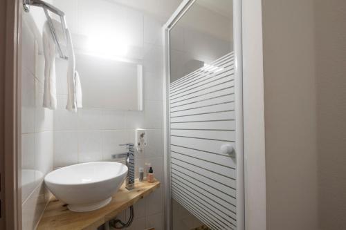 a white bathroom with a sink and a mirror at Garden & City Aix En Provence - Puyricard in Aix-en-Provence