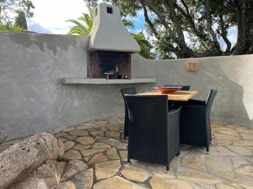 a outdoor table and chairs with a brick oven at Résidence Storia di Blue in Porto-Vecchio