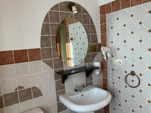 a bathroom with a sink and a mirror at Hotel y Apartamentos Penarronda Playa in Castropol