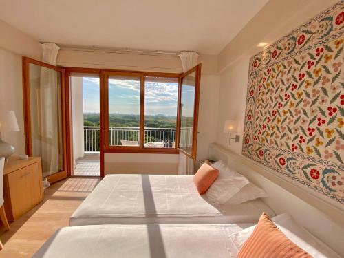 una camera con due letti e una grande finestra di Art&Park Hotel Union Lido a Cavallino-Treporti