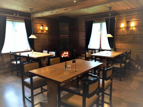 a dining room with tables and chairs and a fireplace at Hammarstrand Budget Hotell- Lergodset in Hammarstrand