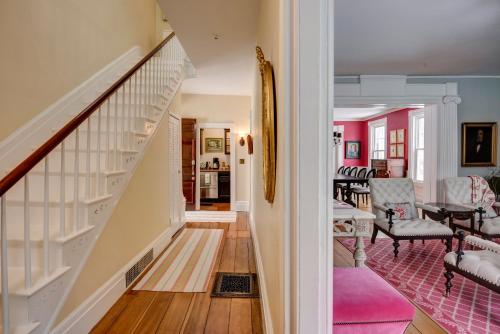 a hallway with a staircase and a living room at 34 State "Historic Luxury Suites" Skaneateles in Skaneateles