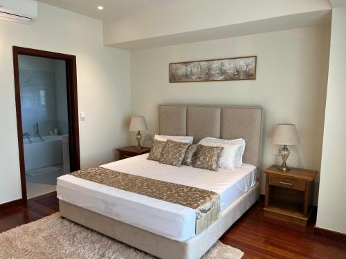 a bedroom with a large bed and a bathroom at Cinnamon Life - Luxury 2 Bedroom Apartment. in Colombo