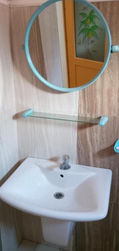 a bathroom with a white sink and a mirror at Pravindi Guest Home in Mirissa