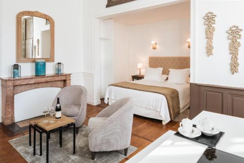 um quarto de hotel com uma cama e uma mesa em La Maison des Courtines em Beaune
