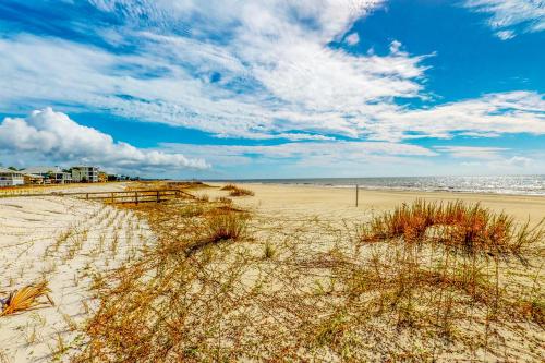a sandy beach with grass in the middle of it at A Wise Way in Indian Pass