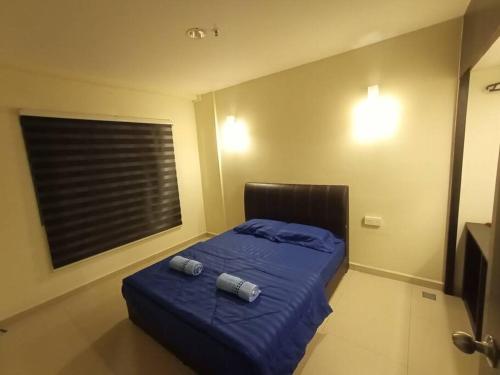 um quarto com uma cama azul com duas almofadas em InstaStay 2-Unit Marina Island Teluk Batik View Lagoon - 1 Bedroom Queen Bed & 2 Single Bed em Lumut