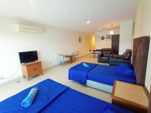 uma sala de estar com uma cama azul e um sofá em InstaStay 2-Unit Marina Island Teluk Batik View Lagoon - 1 Bedroom Queen Bed & 2 Single Bed em Lumut