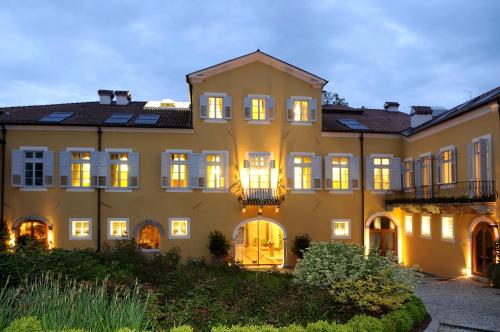 una vista exterior de una casa grande con luces encendidas en Grand Hotel Entourage - Palazzo Strassoldo, en Gorizia