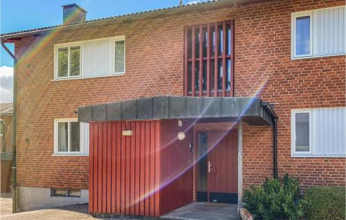 une maison en briques rouges avec un garage rouge dans l'établissement Beautiful Apartment In Hyltebruk, à Hyltebruk