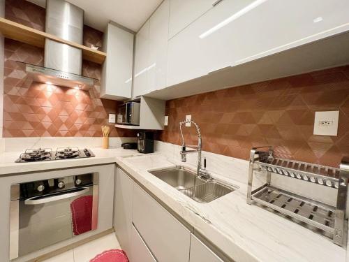 a kitchen with white cabinets and a sink at ITAPARICA SALINAS EXCLUSIVE in Vila Velha