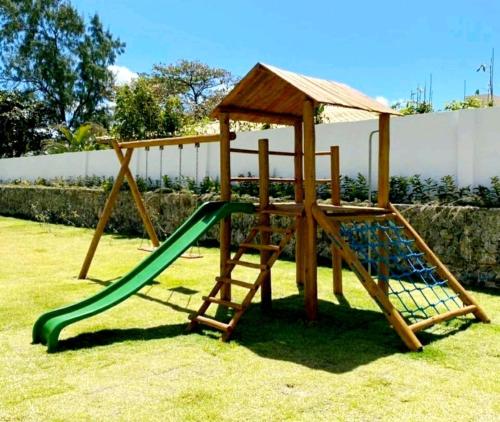 um parque infantil de madeira com um escorrega num quintal em @Paradise_Bahia-Village Novo 2 Suítes Pé na Areia e Vista Mar em Itacimirim em Itacimirim