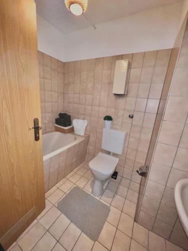 a bathroom with a toilet and a tub and a sink at HamOr Apart nähe westfield in Oberhausen