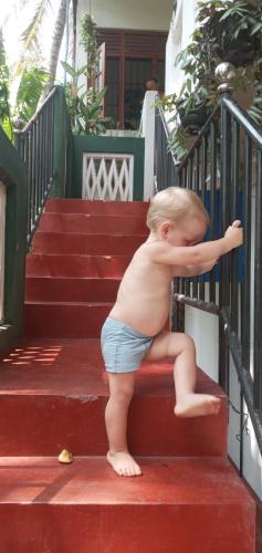 a naked baby standing on the stairs at Pravindi Guest Home in Mirissa