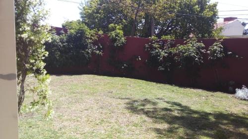 un patio trasero con una valla y un patio de césped en Hotel Las Chirimoyas en Salta