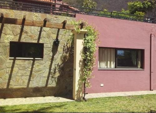 un edificio de ladrillo con una puerta con hiedra. en Hotel Las Chirimoyas en Salta