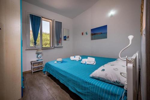 a bedroom with a blue bed with two towels on it at Villa Agapanthus in Castellammare del Golfo