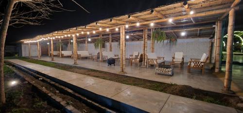 a patio with tables and chairs under a pavilion at night at Apart Hotel El Paraíso de Barranca in Barranca