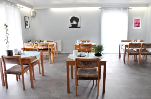 ein Esszimmer mit Tischen und Stühlen in einem Zimmer in der Unterkunft Hotel Garni Haus Dornheim in Obertshausen