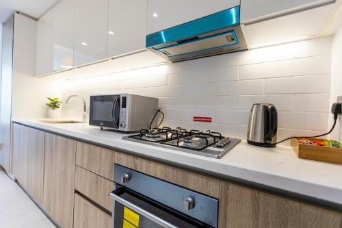 a kitchen with a stove and a microwave at Liv Residence in Dubai