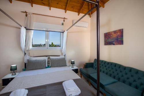 1 dormitorio con cama, sofá y ventana en Ifigeneia's Luxury Resort with Private Hot Tub, en Kalathas